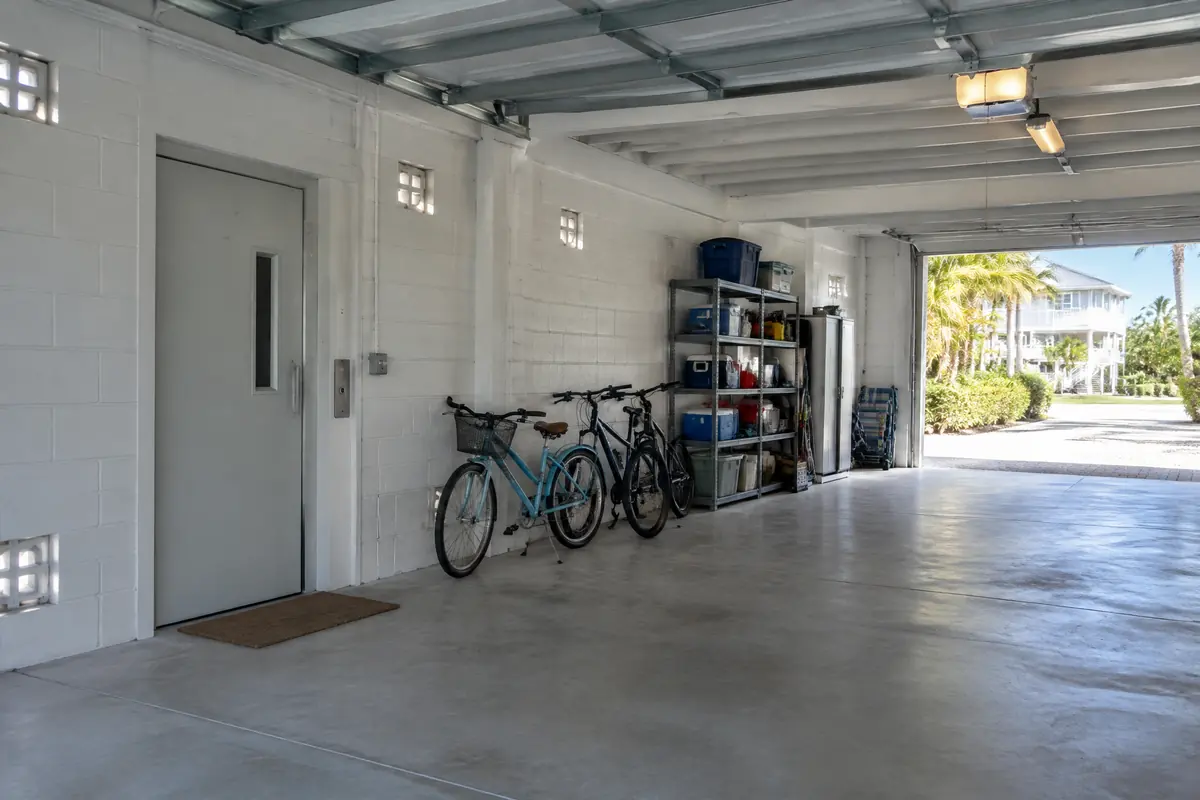 Ground-level enclosure under a raised home with flood vents in the block walls and an elevator door